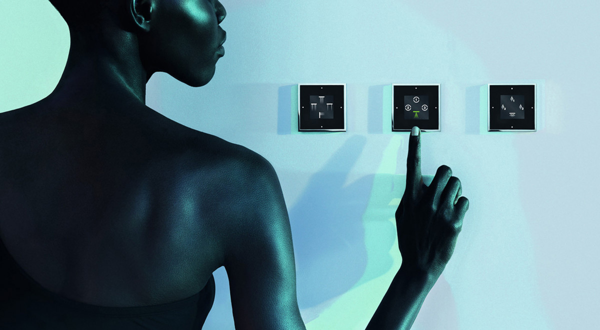 Product photography: A model is using the Smart Water System; the bathroom is lit in blue.