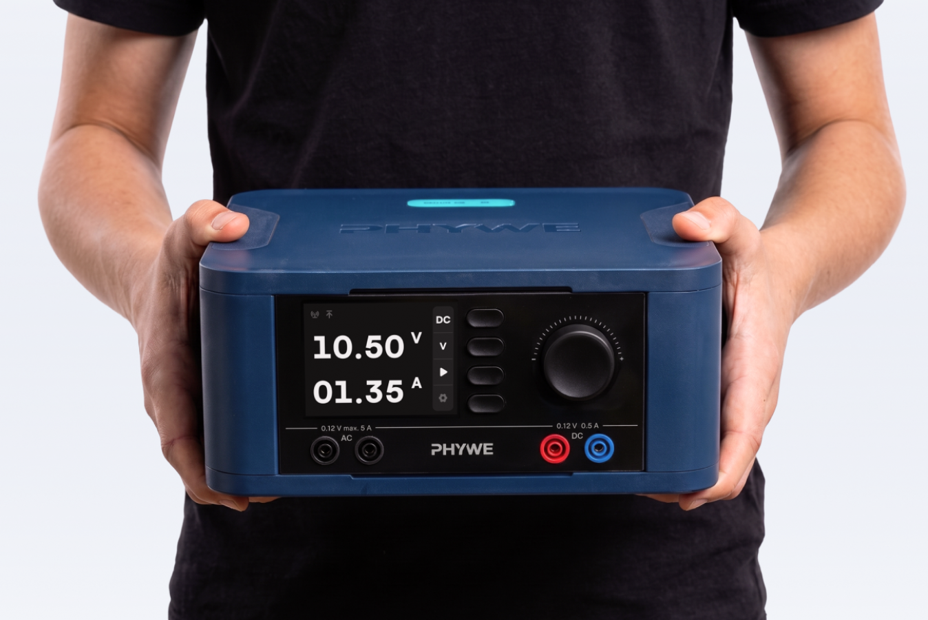 Schüler hält das PHYWE Netzgerät in den Händen - Gestaltung von Squareone